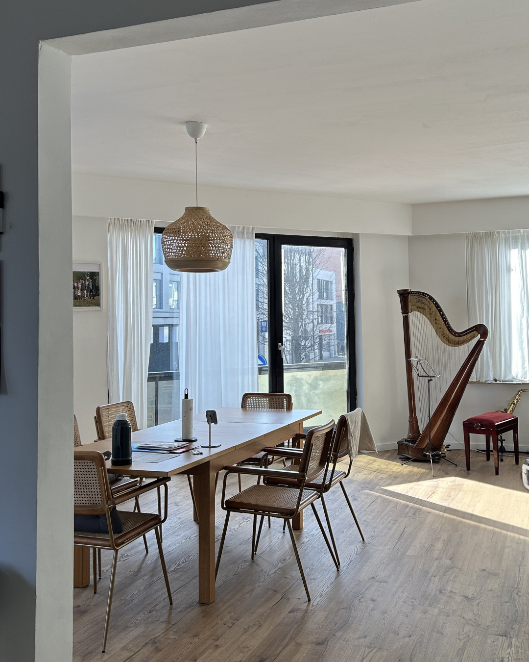 Gerenoveerde eetkamer met houten vloer, eettafel en zicht op de stad