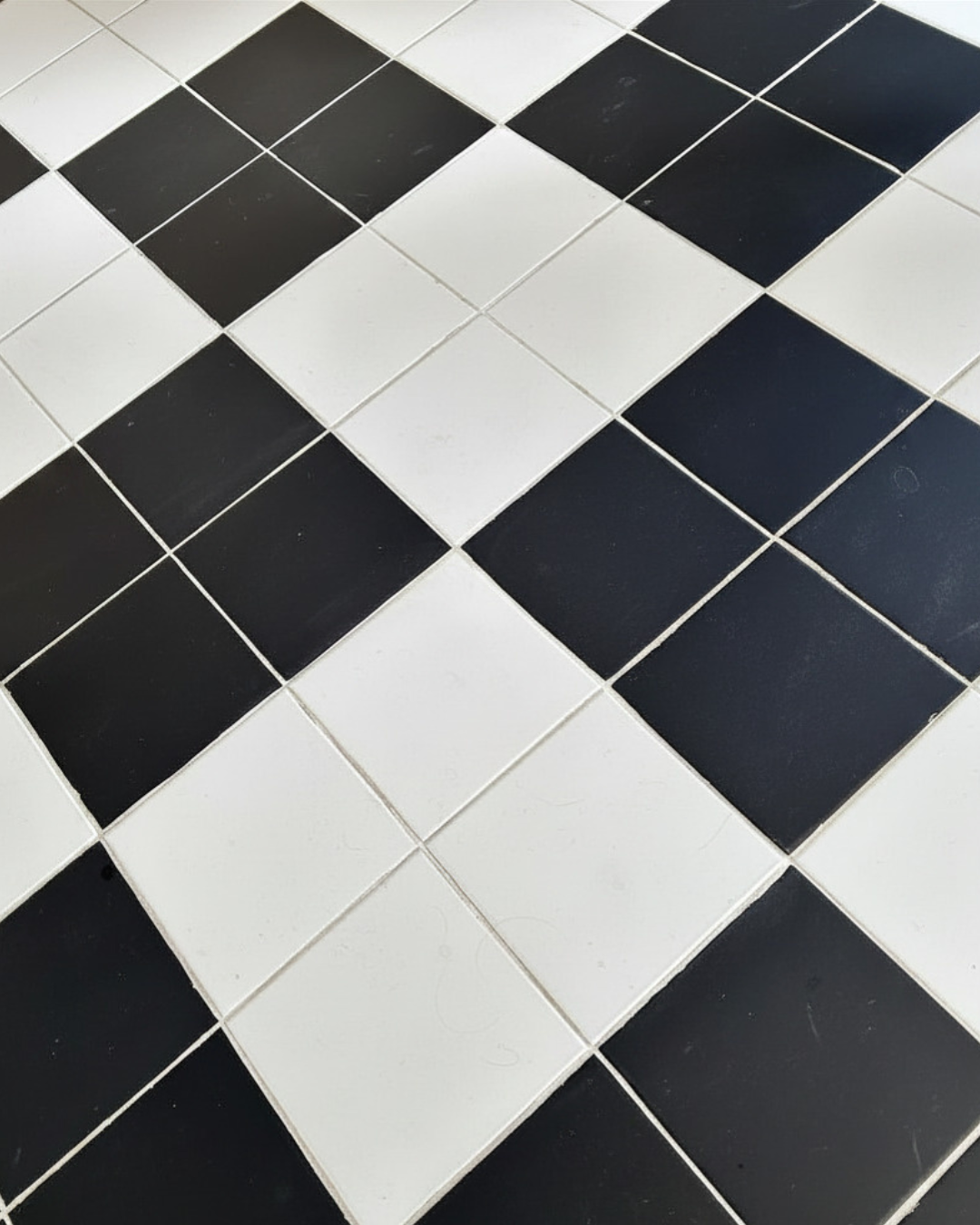 Zwart-witte geblokte tegelvloer, diagonaal gelegd